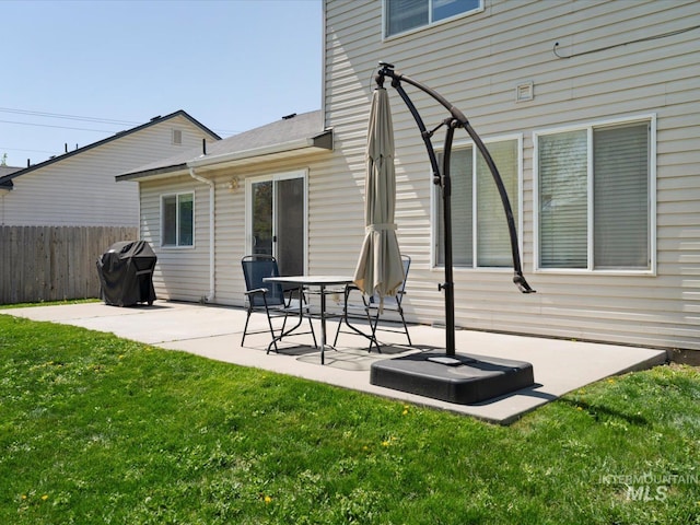 back of house with fence, a patio area, and a lawn