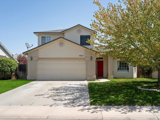traditional home featuring a front lawn, driveway, an attached garage, and fence
