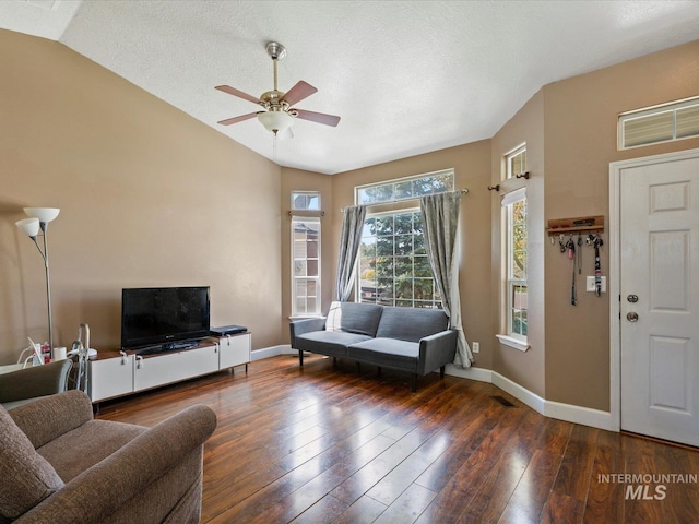 living room featuring hardwood / wood-style flooring, visible vents, lofted ceiling, and baseboards