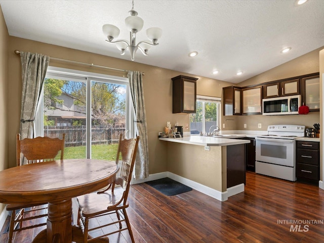kitchen featuring white range with electric stovetop, a peninsula, light countertops, and a notable chandelier