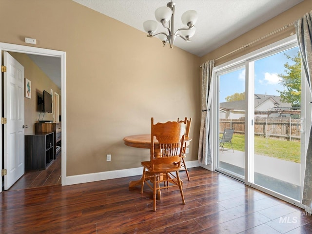 living area featuring wood finished floors, a chandelier, and baseboards