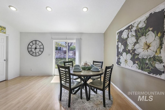 dining area featuring baseboards, wood finished floors, and recessed lighting