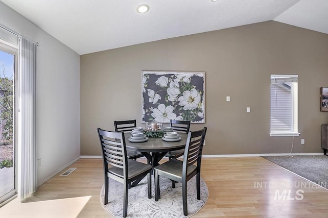 dining area featuring light wood finished floors, vaulted ceiling, baseboards, recessed lighting, and visible vents