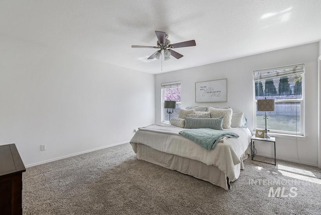 carpeted bedroom with a ceiling fan and baseboards