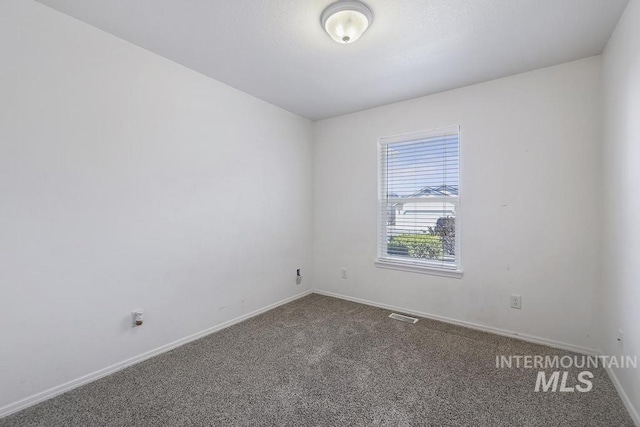 spare room with baseboards, carpet flooring, and visible vents