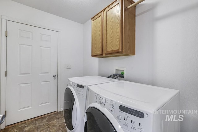 laundry room featuring cabinet space, stone finish flooring, and washer and dryer
