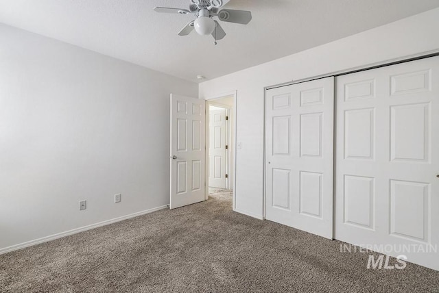 unfurnished bedroom featuring carpet floors, a closet, baseboards, and ceiling fan