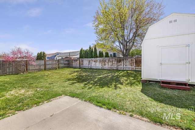view of yard featuring a storage unit, a patio area, an outbuilding, and a fenced backyard