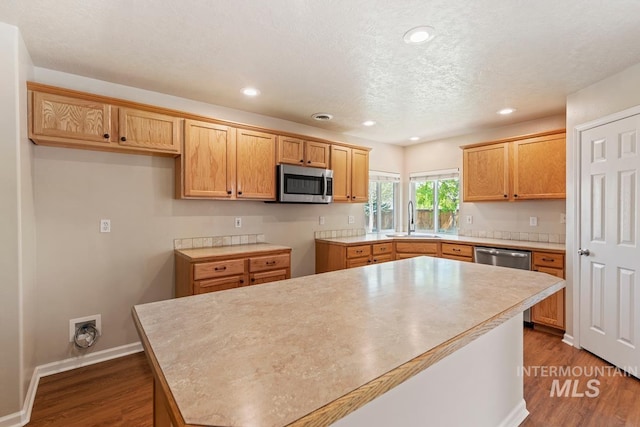 7362 S Shadowmoss Ave, Boise, ID 83709 - kitchen featuring stainless steel appliances, a sink, dark wood-style flooring, recessed lighting, and light countertops