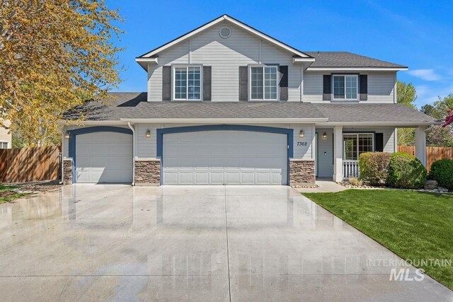 7362 S Shadowmoss Ave, Boise, ID 83709 - view of front of property with driveway, stone siding, and a shingled roof