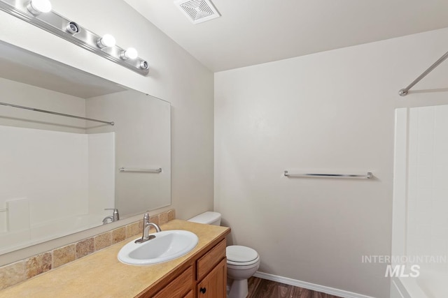7362 S Shadowmoss Ave, Boise, ID 83709 - bathroom with toilet, washtub / shower combination, vanity, and wood finished floors