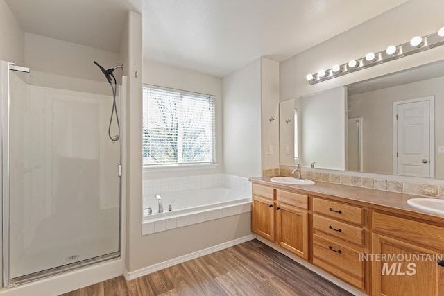 7362 S Shadowmoss Ave, Boise, ID 83709 - full bathroom featuring a stall shower, double vanity, wood finished floors, and a garden tub