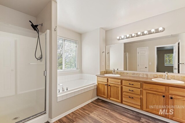 7362 S Shadowmoss Ave, Boise, ID 83709 - bathroom featuring a stall shower, double vanity, a bath, and wood finished floors