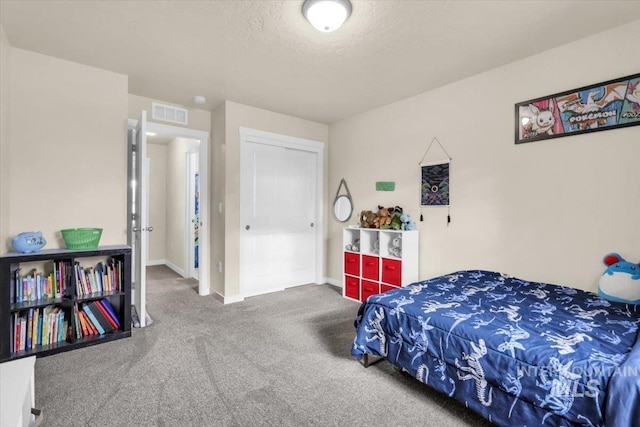 bedroom with carpet flooring, baseboards, and a textured ceiling