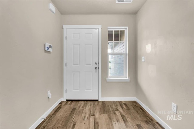 foyer with baseboards and wood finished floors