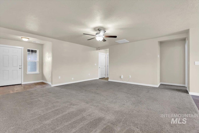 unfurnished living room with carpet flooring, a ceiling fan, and baseboards