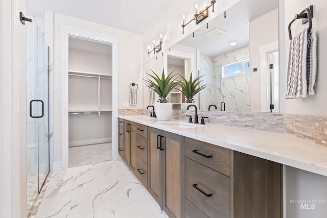 1501 E Andes Dr, Kuna, ID 83634 - bathroom featuring a marble finish shower, double vanity, backsplash, and marble look tiles