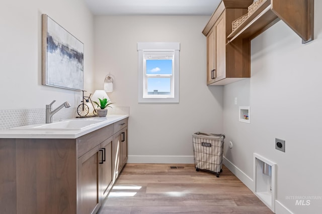 1501 E Andes Dr, Kuna, ID 83634 - laundry room featuring hookup for an electric dryer, light wood-style floors, washer hookup, and cabinet space