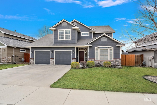 craftsman house with a front yard, fence, driveway, an attached garage, and stone siding