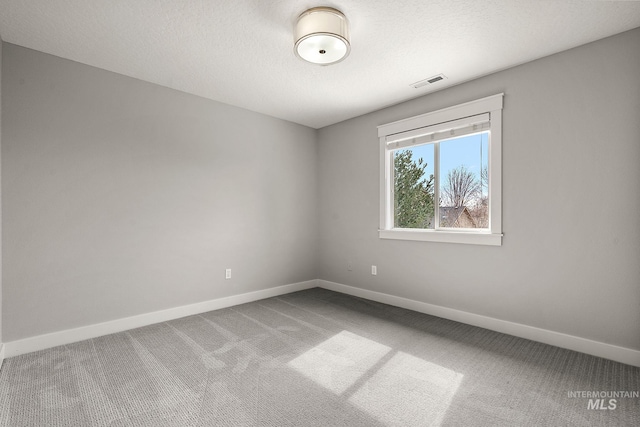 empty room with visible vents, carpet floors, and baseboards