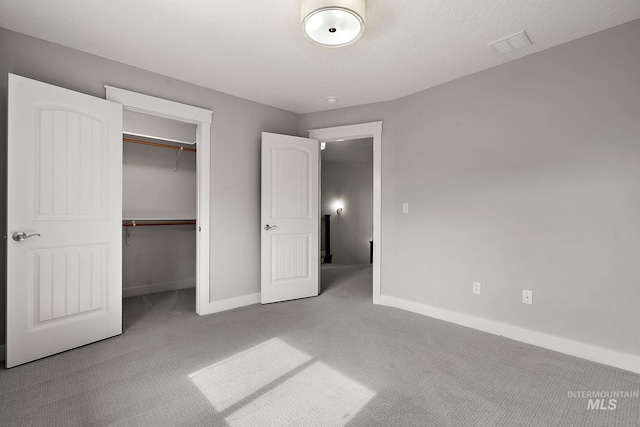 unfurnished bedroom with a closet, visible vents, baseboards, and carpet floors