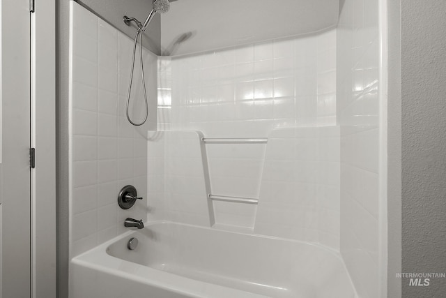 bathroom featuring shower / bath combination and a textured wall