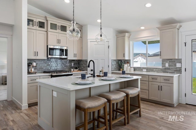 958 Gregory Way, Twin Falls, ID 83301 - kitchen featuring stainless steel appliances, a sink, a kitchen breakfast bar, light countertops, and backsplash