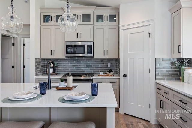 958 Gregory Way, Twin Falls, ID 83301 - kitchen featuring stainless steel appliances, a kitchen bar, light countertops, pendant lighting, and a sink