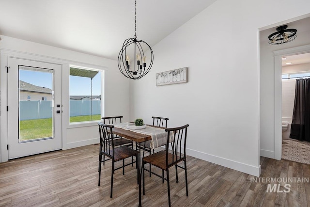 958 Gregory Way, Twin Falls, ID 83301 - dining area featuring a chandelier, lofted ceiling, wood finished floors, and baseboards