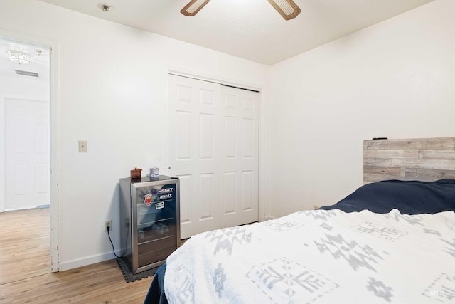 bedroom featuring light wood-type flooring, ceiling fan, and a closet