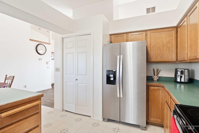 kitchen featuring range with electric cooktop and stainless steel refrigerator with ice dispenser