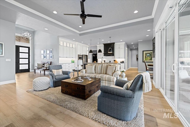 1427 N Morehouse, Eagle, ID 83616 - living room with a tray ceiling, a chandelier, a ceiling fan, light wood-type flooring, and recessed lighting