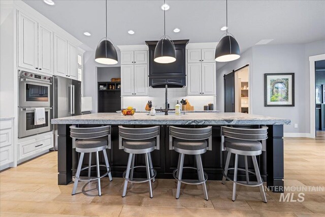 1427 N Morehouse, Eagle, ID 83616 - kitchen featuring appliances with stainless steel finishes, white cabinetry, backsplash, a kitchen island with sink, and recessed lighting