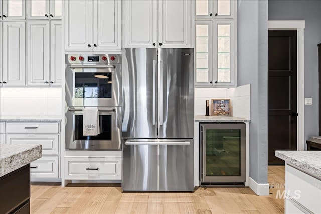 1427 N Morehouse, Eagle, ID 83616 - kitchen with appliances with stainless steel finishes, wine cooler, white cabinets, and light wood finished floors