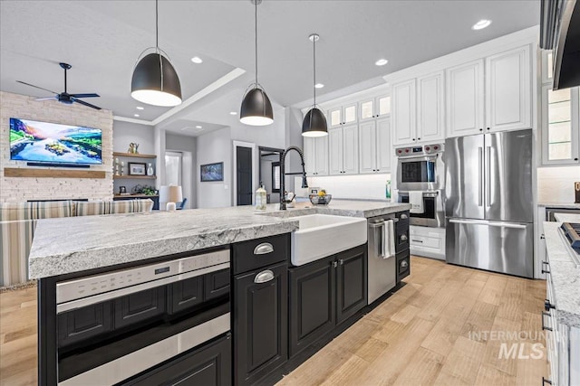 1427 N Morehouse, Eagle, ID 83616 - kitchen featuring stainless steel appliances, dark cabinetry, white cabinets, a sink, and light wood finished floors
