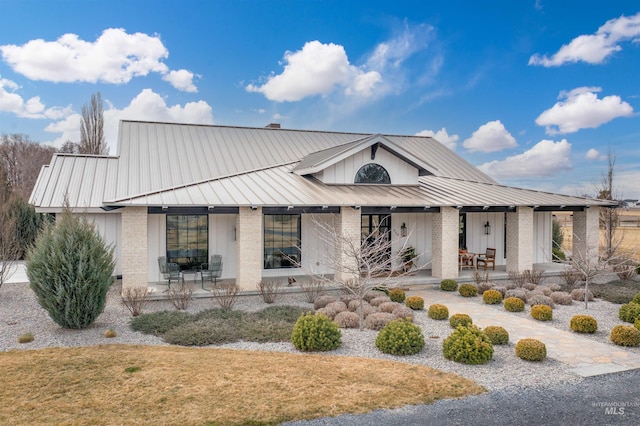 modern farmhouse featuring metal roof, a standing seam roof, and covered porch