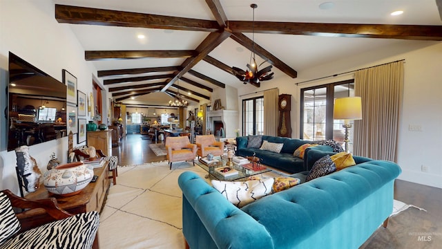 living area featuring lofted ceiling with beams, baseboards, and an inviting chandelier