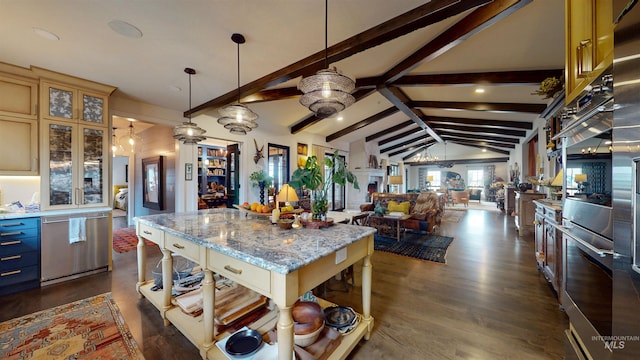 kitchen featuring lofted ceiling with beams, stainless steel dishwasher, a center island, open floor plan, and hanging light fixtures