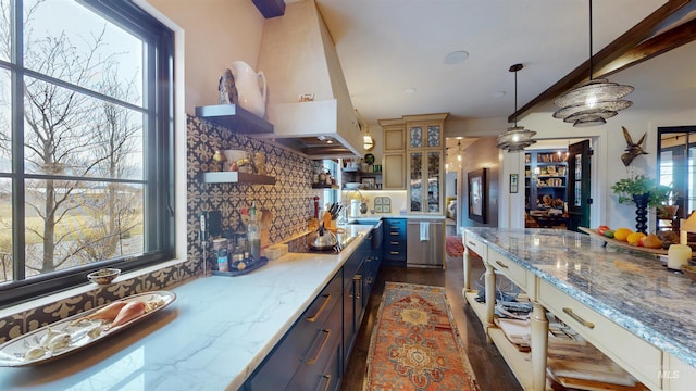 kitchen featuring glass insert cabinets, a wealth of natural light, open shelves, and decorative backsplash