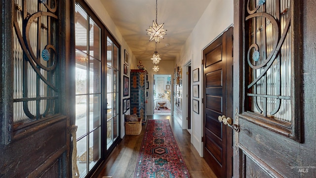 entryway with french doors, a notable chandelier, and wood finished floors