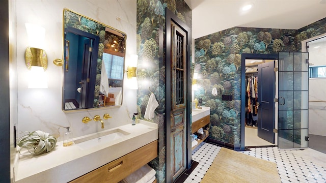 full bath with a spacious closet, wallpapered walls, and vanity