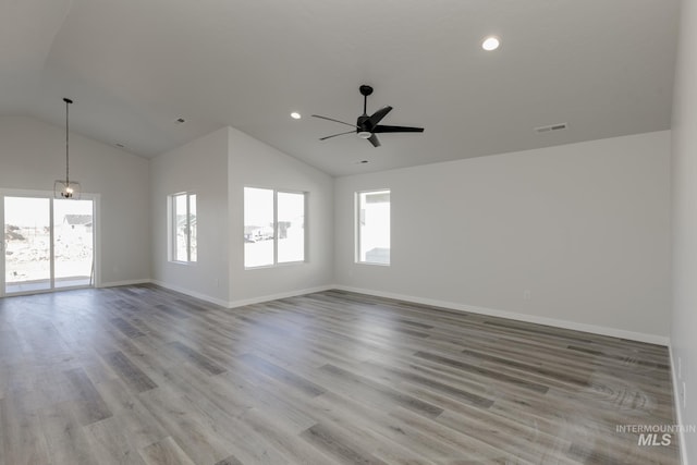 empty room featuring vaulted ceiling, baseboards, a ceiling fan, and visible vents