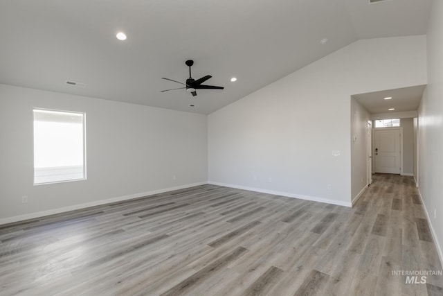 spare room with a wealth of natural light, visible vents, ceiling fan, and vaulted ceiling