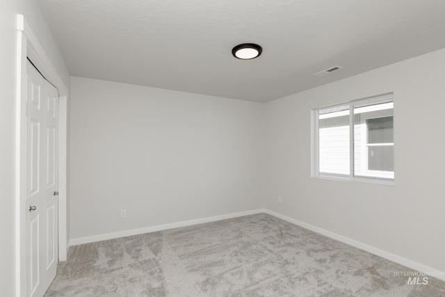unfurnished bedroom featuring carpet, baseboards, and visible vents