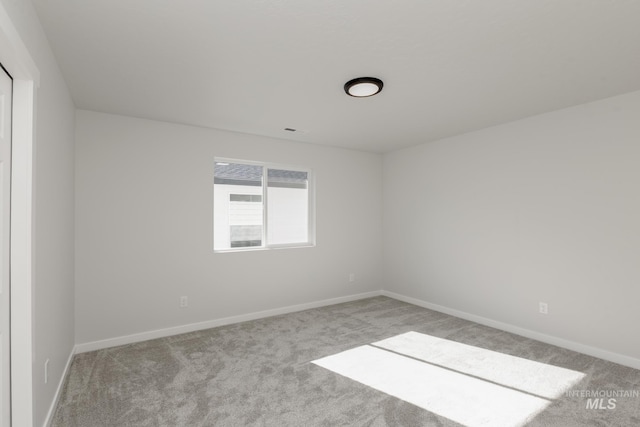 carpeted spare room with baseboards
