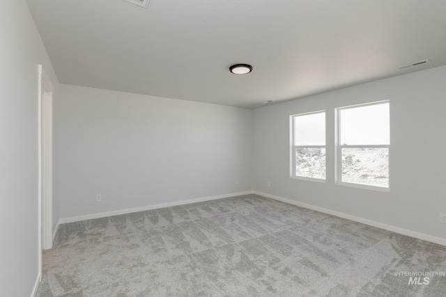unfurnished room with carpet flooring, visible vents, and baseboards