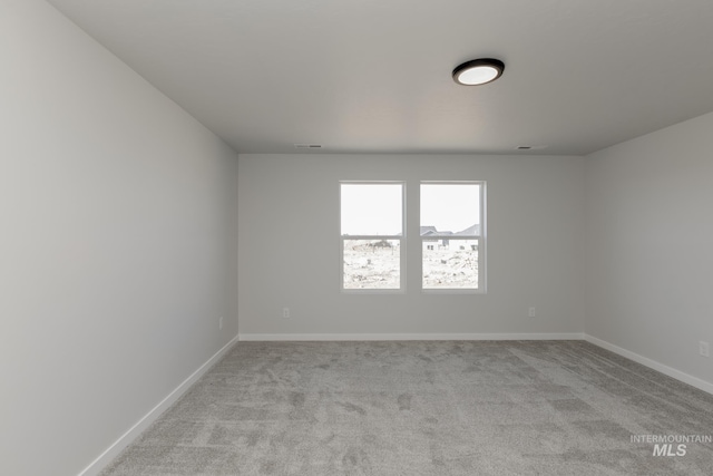 empty room featuring carpet flooring, baseboards, and visible vents