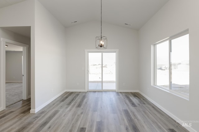 unfurnished dining area featuring an inviting chandelier, lofted ceiling, visible vents, and light wood-style floors