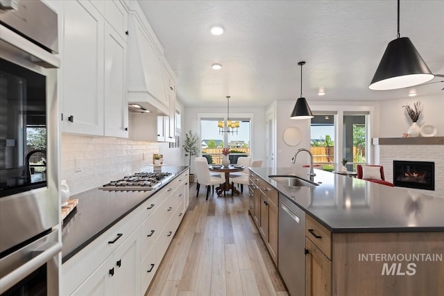 499 S Short Ln, Eagle, ID 83616 - kitchen with appliances with stainless steel finishes, dark countertops, light wood-style flooring, backsplash, and white cabinets