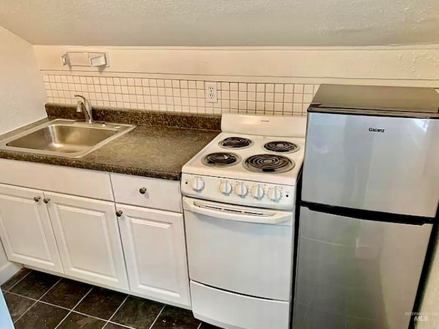 kitchen with stainless steel fridge, tasteful backsplash, white cabinetry, white electric range, and sink